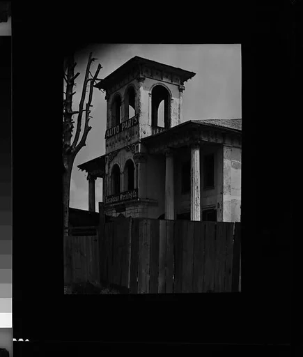 [Converted Italianate Revival House Behind Fence, Wrecking Company Near Tuscaloosa, Alabama]