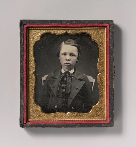 [Boy in Wide Lapelled Coat, Seated in Chair]