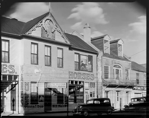 [Storefront Façades Including Lum Brothers Stables with Parked Cars on Street, Natchez, Mississippi]