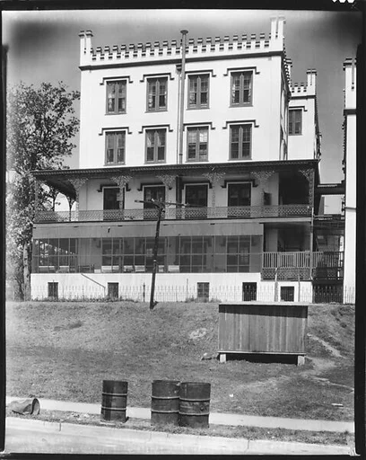 [Gothic Revival Building with Turreting, Cast-Iron Grillwork, and Garbage Cans on Street, New Orleans, Louisiana?]