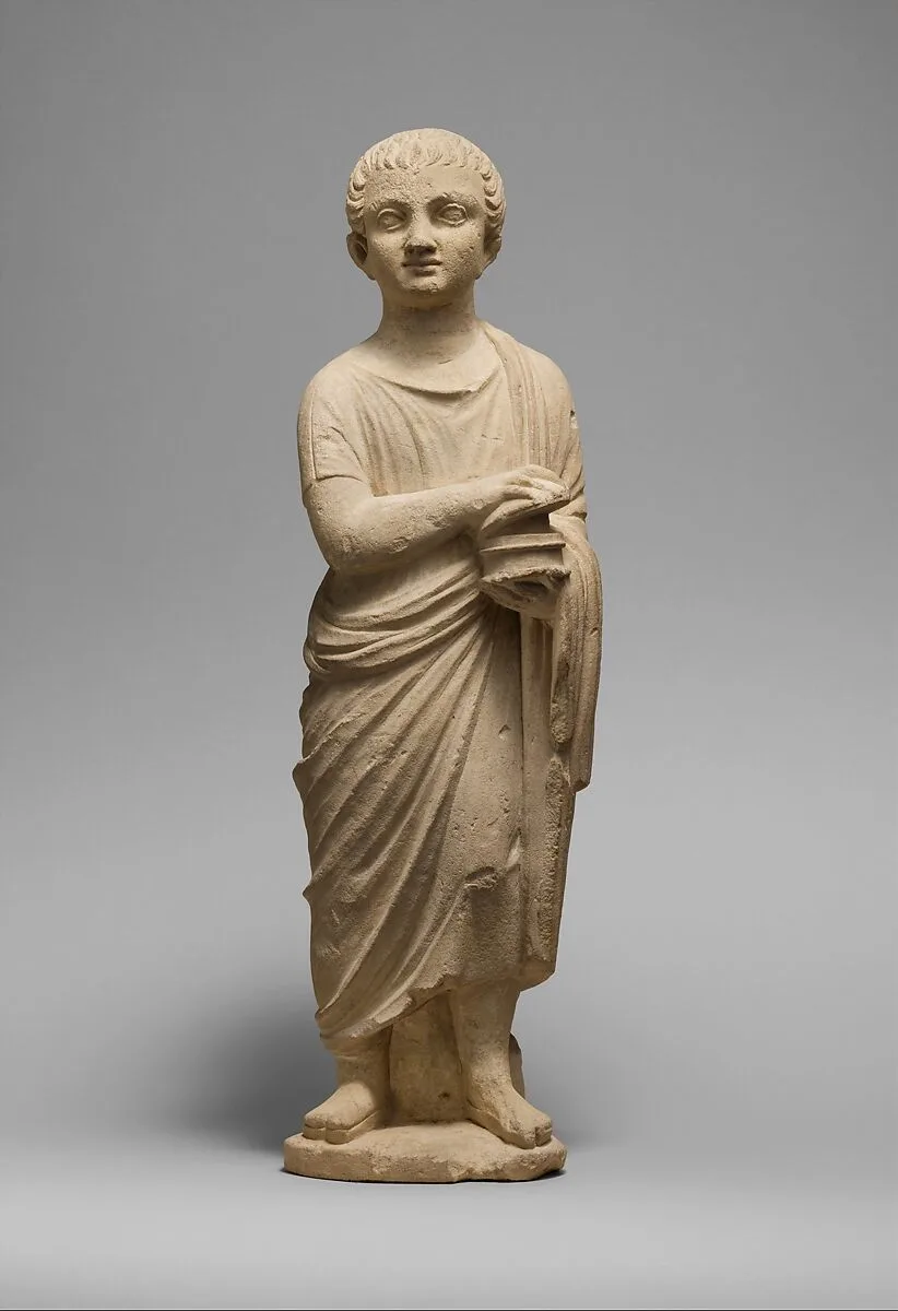 Limestone statue of a youth holding a pyxis — Unknown