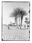 Distant mosque with palms and two figures — Unknown