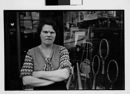 [Two 35mm Film Frames: Woman Outside Main Street Sports Shop, Old Woman Outside Main Street Grocery Store, Ossining, New York]