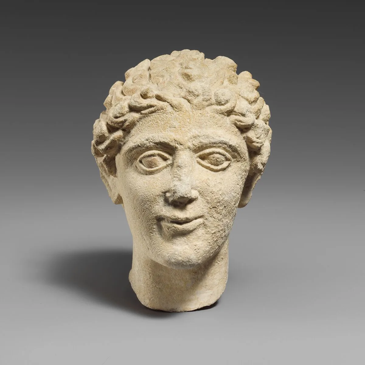 Limestone head of a beardless male votary — Unknown