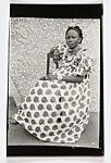 Young Woman Seated in Apple Print Dress