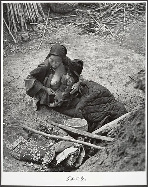 After the bombardments, this mother is one of many who keep alive by eating herbs and roots, Taiherhchwang — Robert Capa
