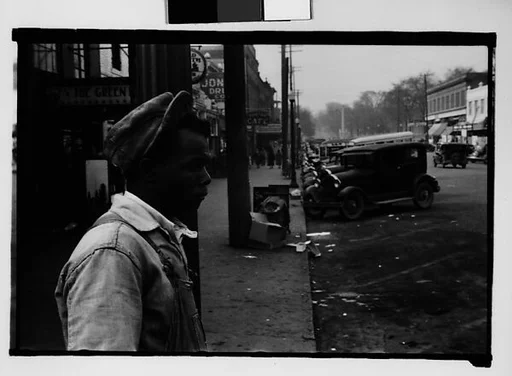 [Man Leaning on Lamppost on Main Street, Milledgeville, Georgia]