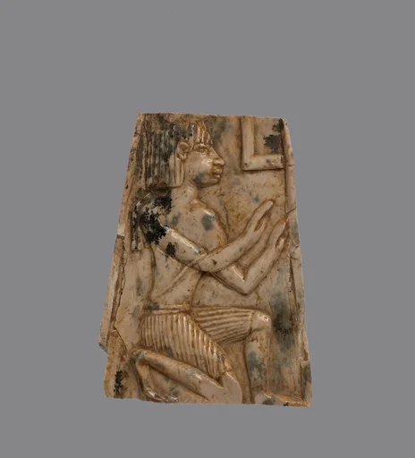 Plaque carved in relief with kneeling figure