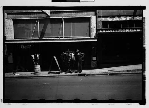 [Man with Clothesrack on Sidewalk, Natchez, Mississippi]