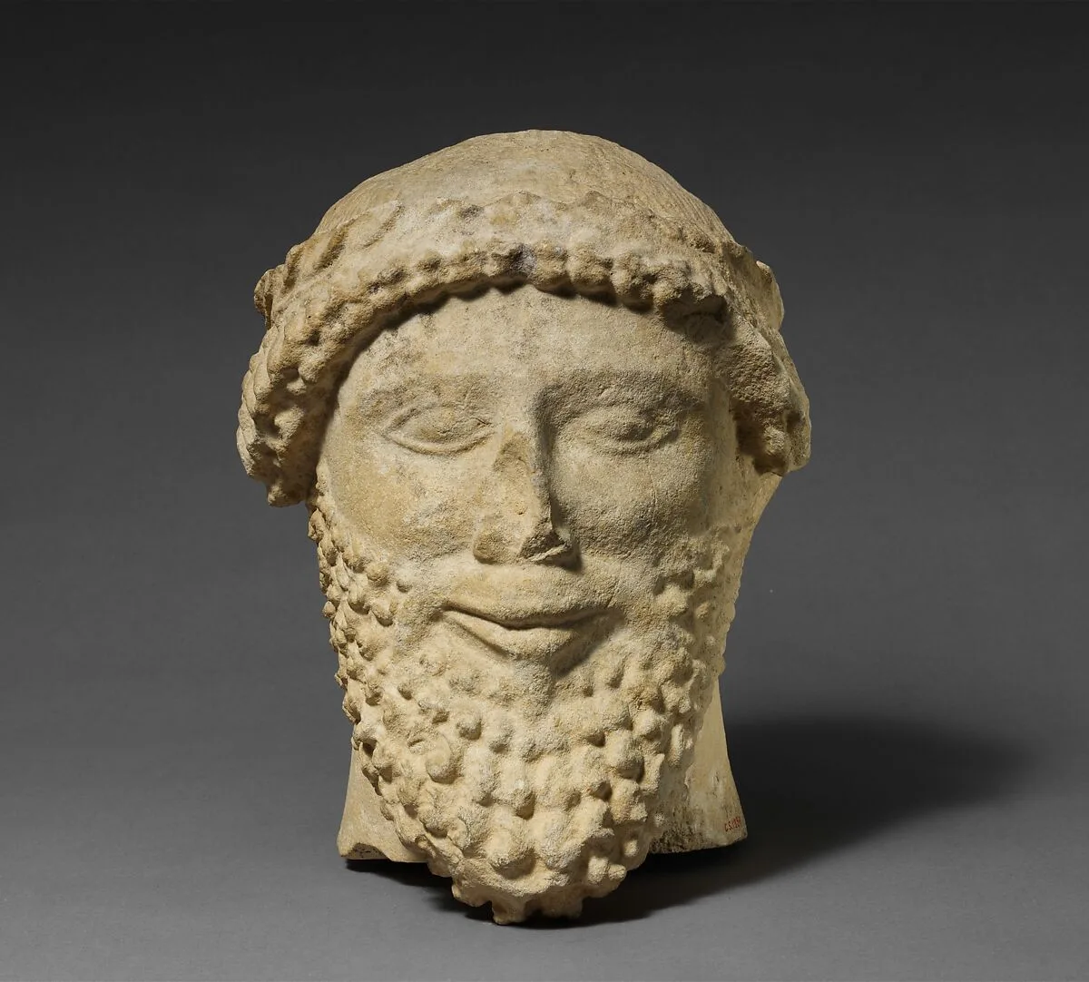 Limestone head of a bearded male with a wreath of leaves — Unknown