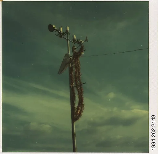 [Sign: Angel Ornament Attached to Light Pole]