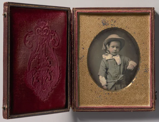 [Child Wearing Straw Hat, Arm Resting on Table]