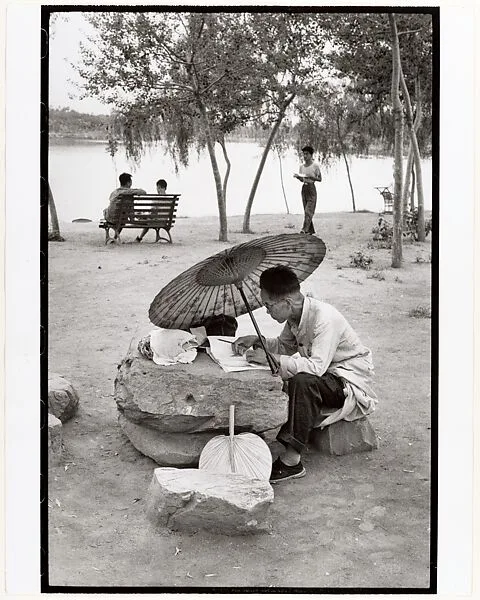 A Professor Corrects His Class Papers by the Lake in the Newly Build King Chan Park, Peking — Henri Cartier-Bresson
