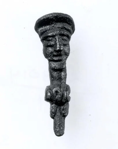 Head of a pin: seated figure with cap
