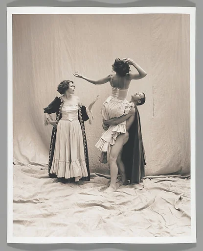 [Standing Male Nude Lifting Woman in Arms with Another Woman Looking On Nearby]