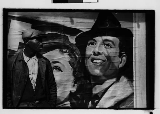 [Five 35mm Film Frames: Man in Front of Movie Poster, Man Seated on Flatbed Wagon in Yard, Vicksburg or New Orleans]