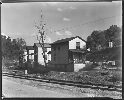 [Row of Clapboard "Company" Houses for Miners Along Railroad Tracks and Creek, Osage, West Virginia]