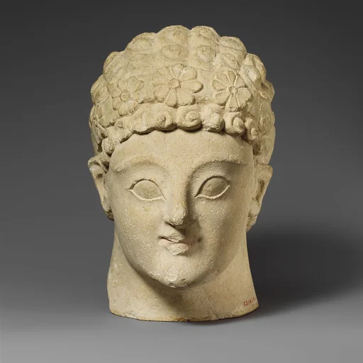 Limestone head of a beardless male
