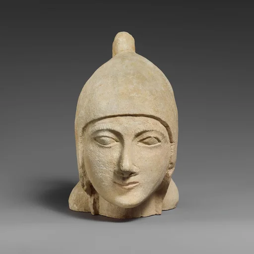 Limestone head of a beardless male wearing a conical helmet