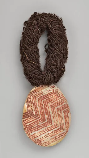 Engraved pearl shell with human hair string