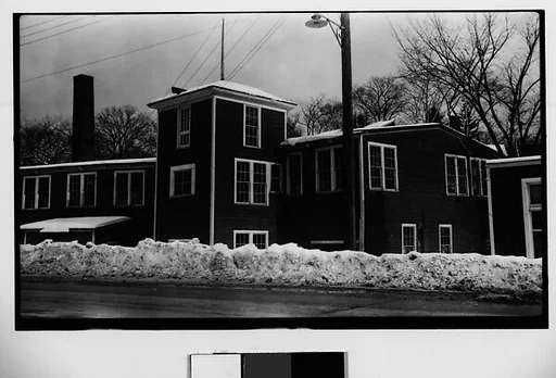 [Wooden Clapboard Building Behind Snow Bank]