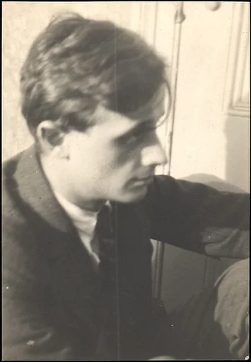 [Hanns Skolle, Seated on Floor in Doorway]