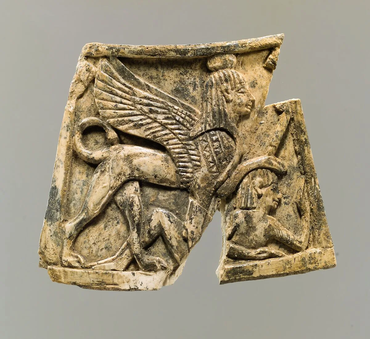 Plaque carved in relief with sphinx trampling figure — Unknown