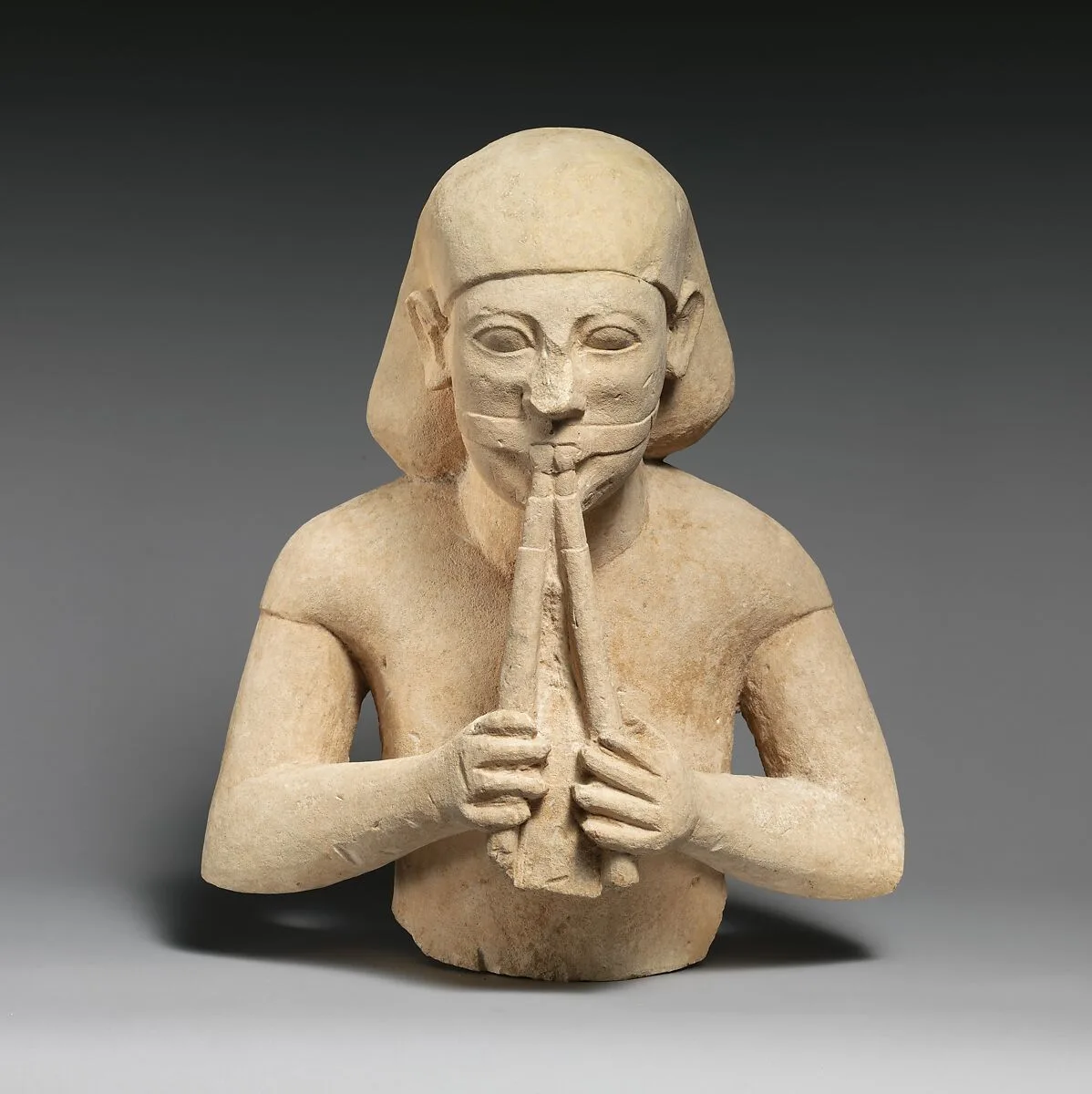 Limestone bust of a flute-player — Unknown