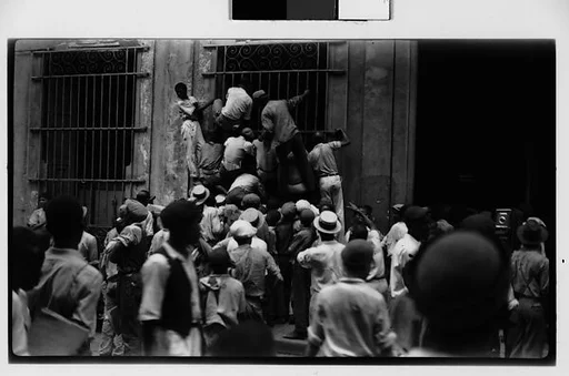 [Newsboys Climbing Iron Grillwork Door, Havana]