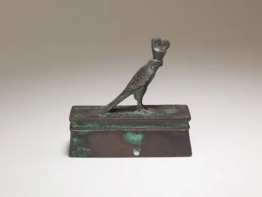 Falcon in double crown surmounting a shrine form box for an animal mummy