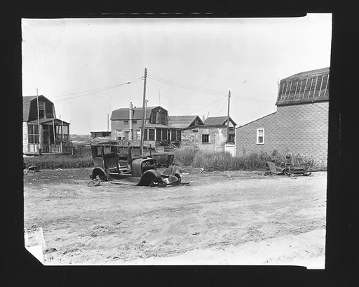 [Junked Car in Lot Before Clapboard Beachfront Houses, Possibly Canarsie, Brooklyn, New York?]