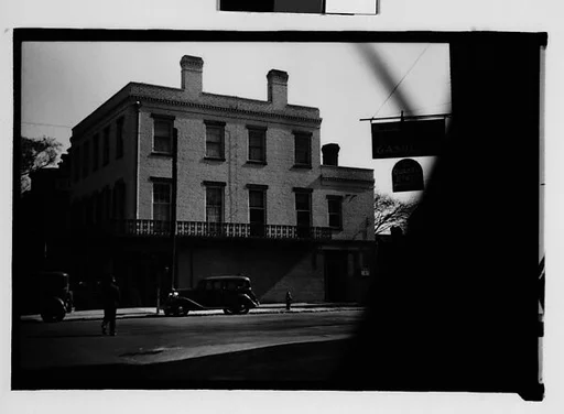 [Flat-Roofed Brick Building with Parked Car on Street, From Automobile, Savannah, Georgia]