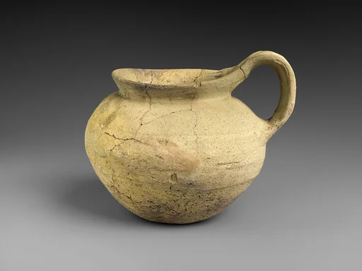 Pitcher with twisted strap handle