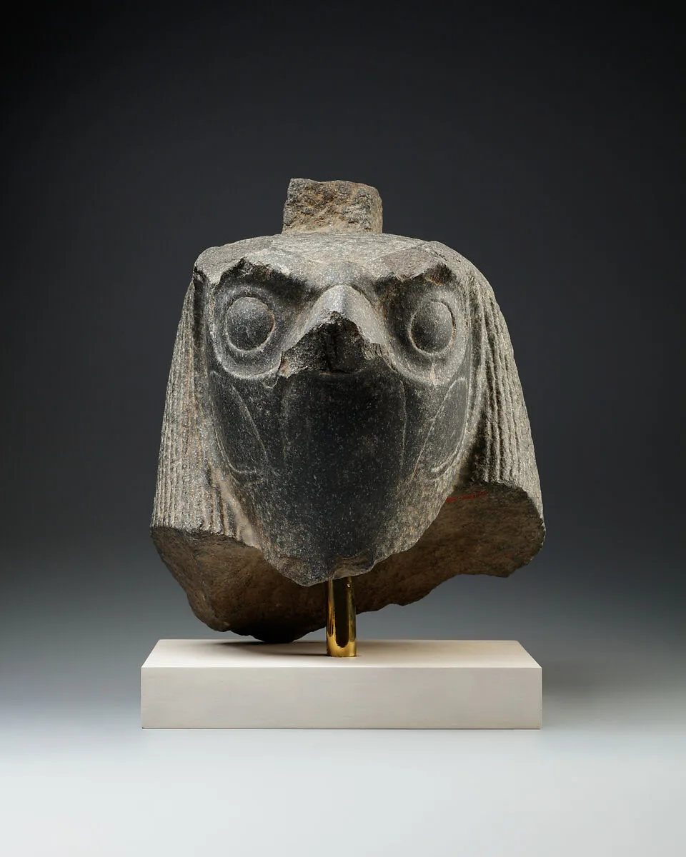 Falcon head with divine wig from a statue with an anthropomorphic body — Unknown