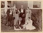 [Group of People in Fancy Dress Posed Outside of House]