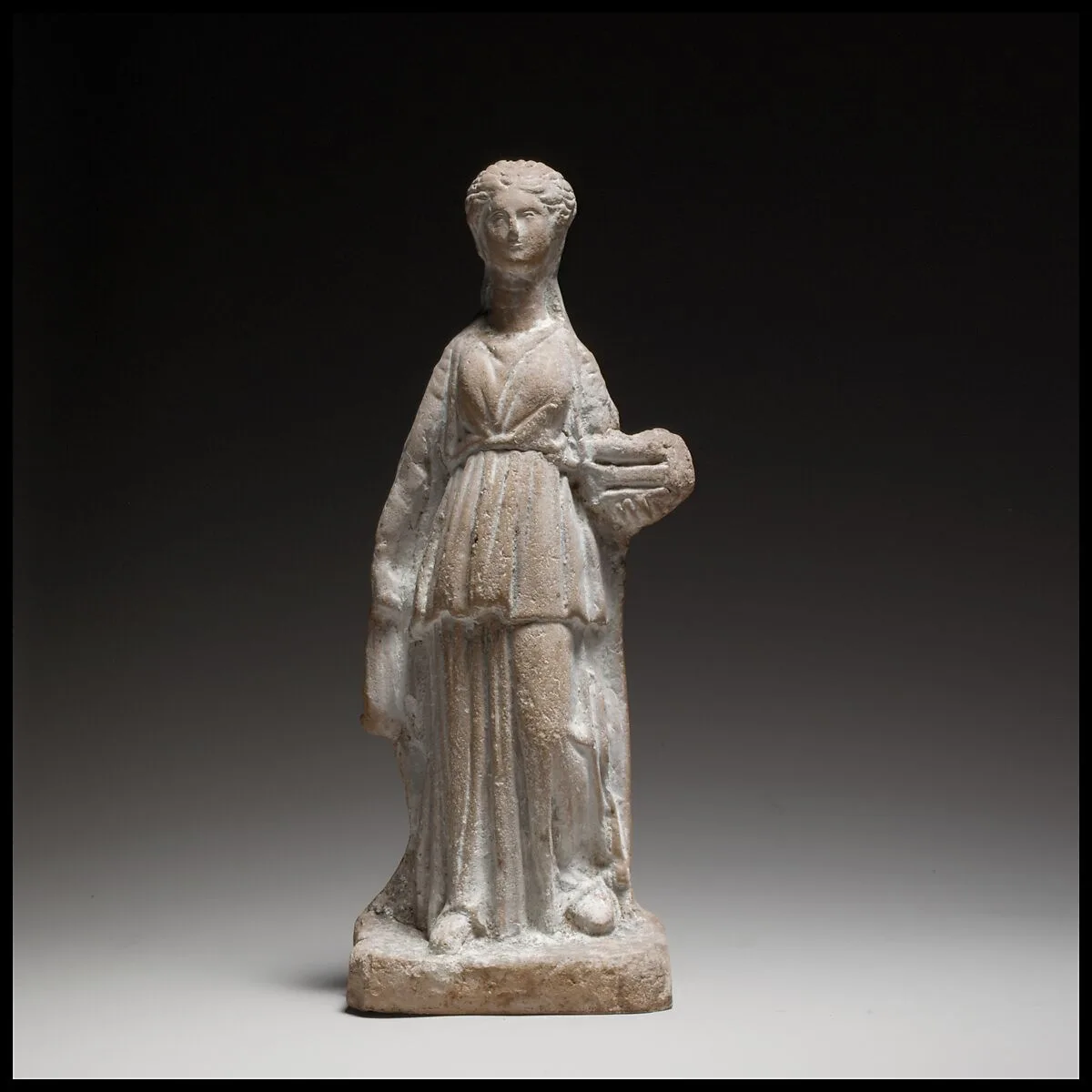 Terracotta figuring of a standing female votary holding a box — Unknown