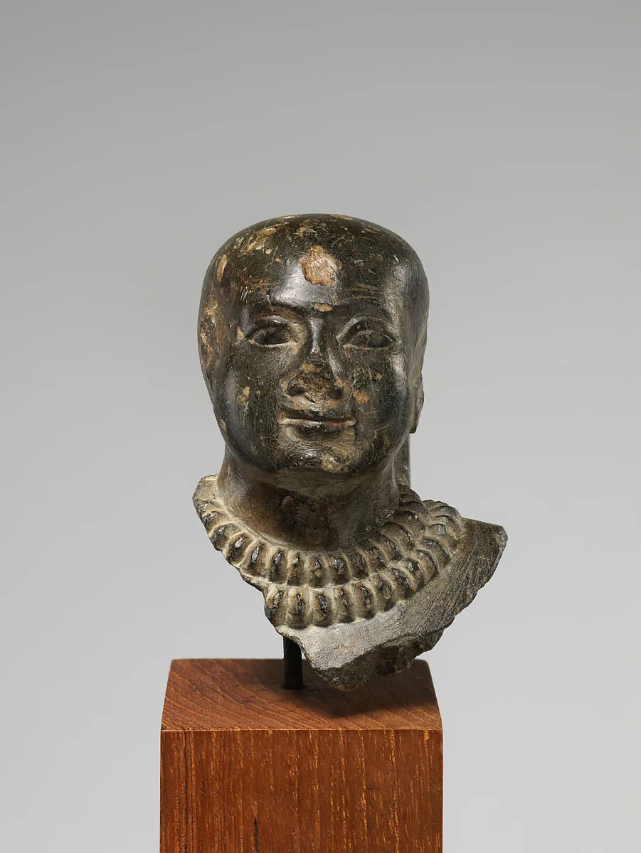 Bald-headed Man Wearing Gold Collars — Unknown