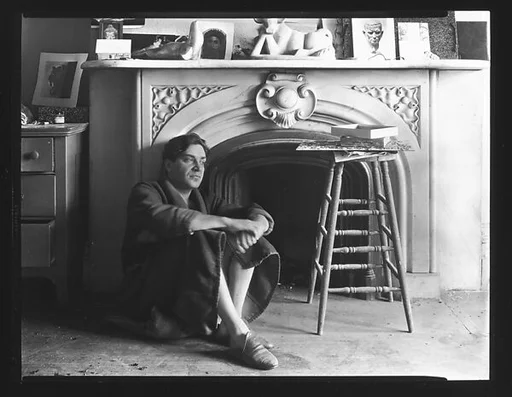 [Reuben Nakian Seated Against Fireplace Mantle]