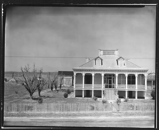 [Two Story House Behind Wooden Fence]