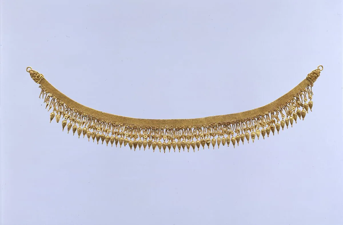 Gold strap necklace with seedlike pendants — Unknown