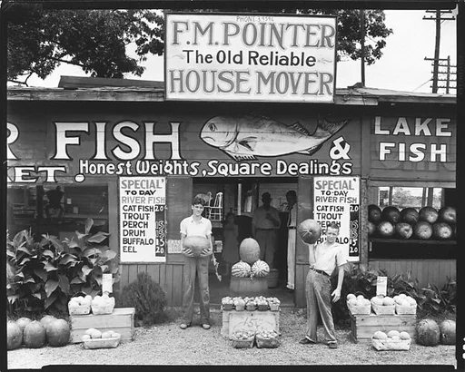 [Roadside Fish and Produce Stand with Young Men Holding Watermelons, Near Birmingham, Alabama]