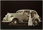 [Advertisement for Chevrolet: Woman in Evening Gown in front of a Chevrolet]