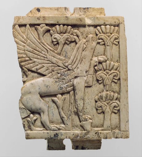 Furniture plaque carved in relief with a griffin in a floral landscape