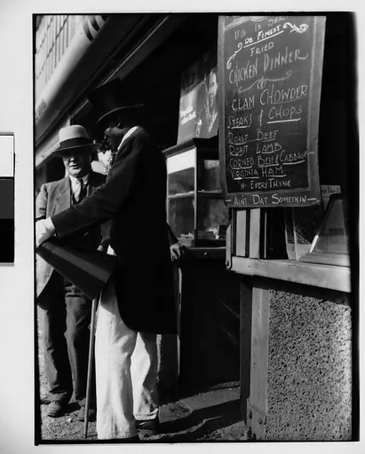 [Barker Talking to Man in Suit in Front of Food Stand, New York City]